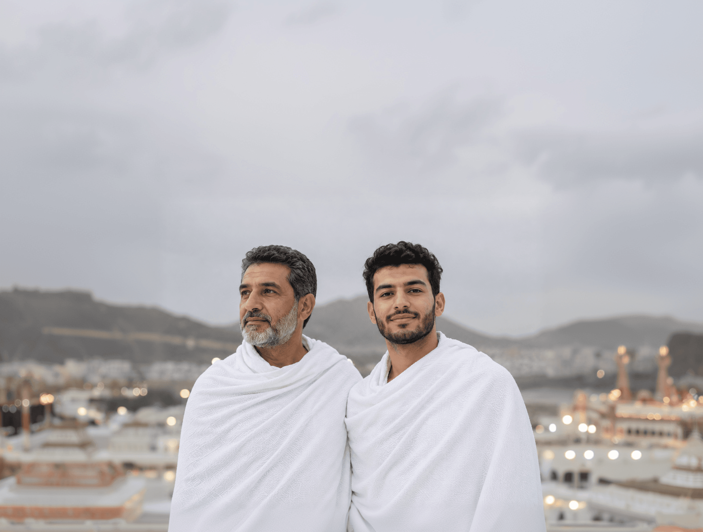 حاجّان في الإحرام وجبال مكة من خلفهما