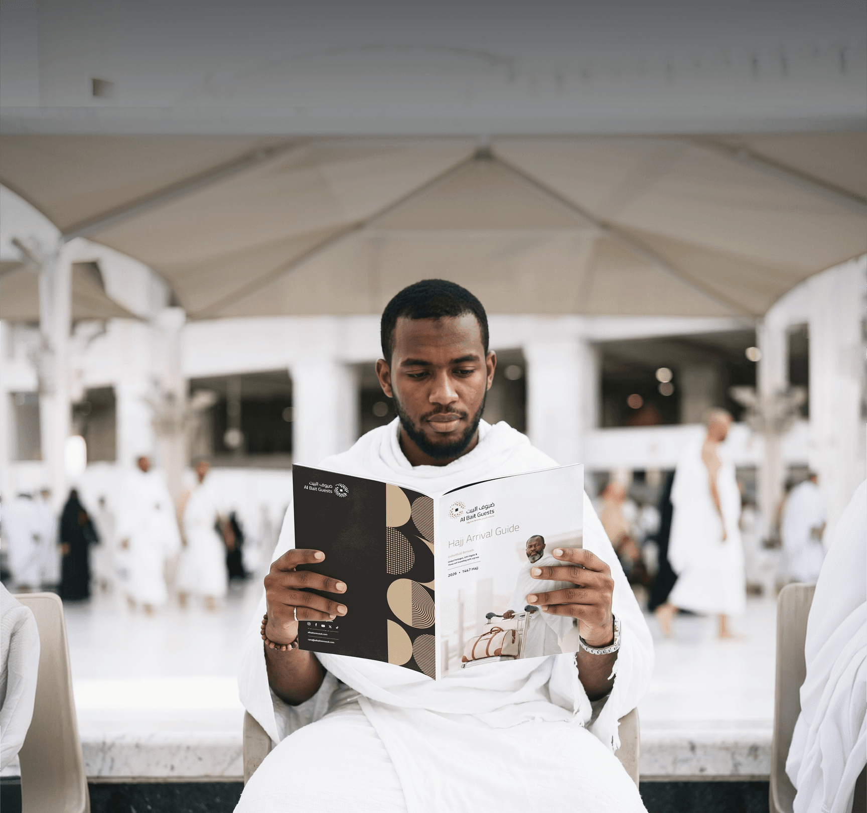 حاج يرتدي الإحرام ويقرأ دليل الوصول إلى الحج من ضيوف البيت