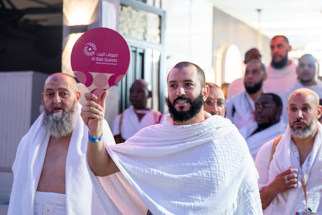 مرشد يحمل لافتة أمام مجموعة من الحجاج